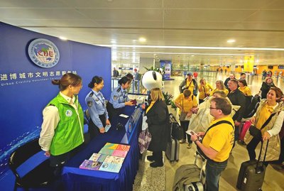 移民管理警察在进博会城市文明志愿服务站 为外籍旅客提供通关与游学咨询服务